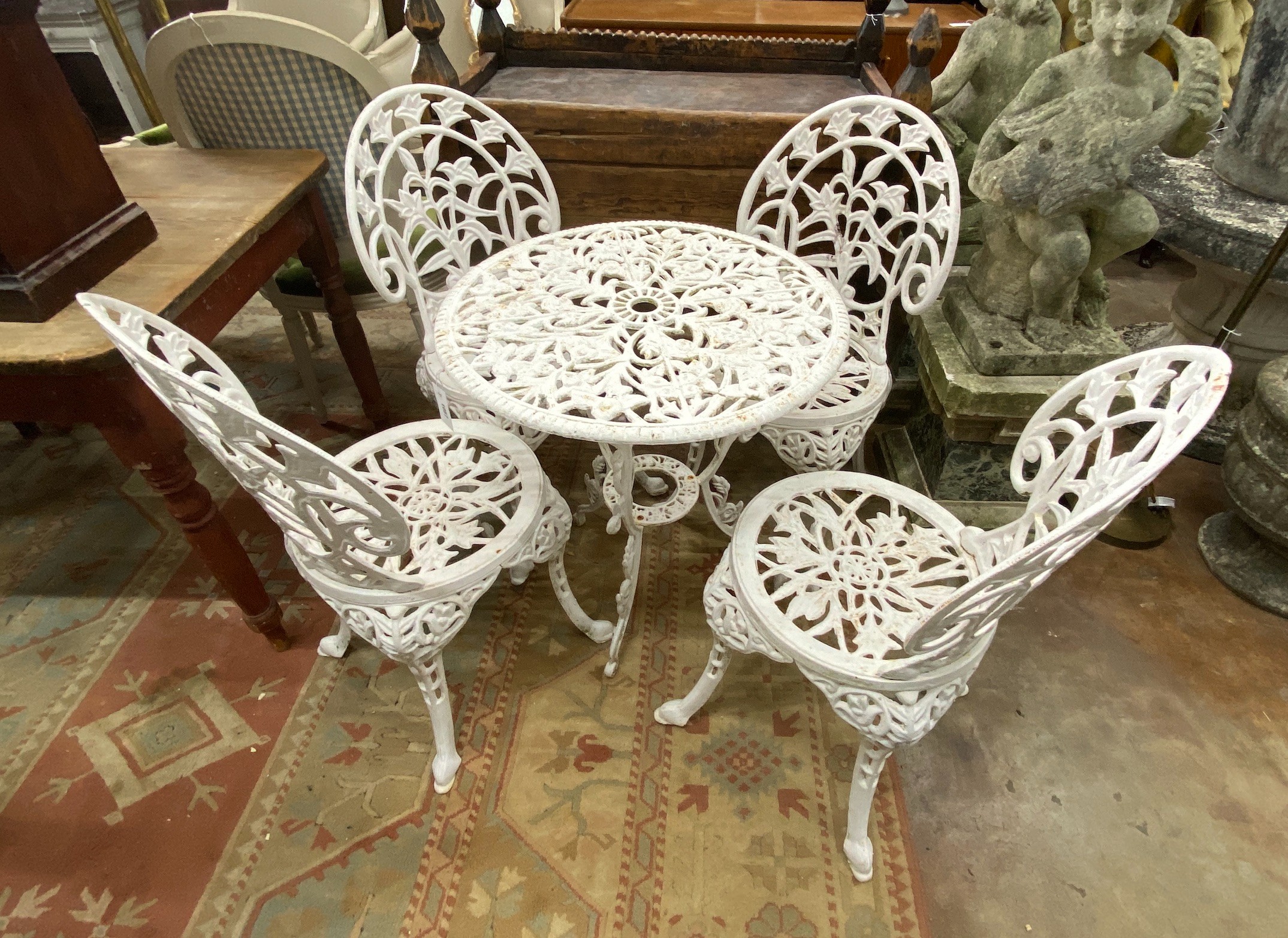 A Victorian style painted cast iron circular garden table, diameter 62cm, height 67cm together with four matching chairs